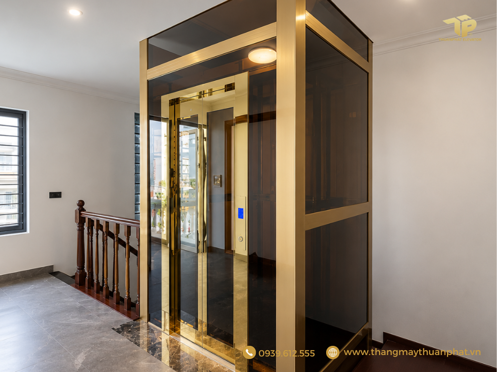 Mẫu thang máy gia đình khung nhôm vàng đồng kính màu trà